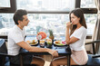 © blackday - Happy couple eating healthy breakfast in modern apartment with large windows and city view