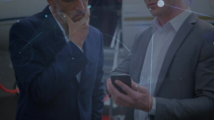 Poster - Animation of connections over caucasian businessmen with smartphone in front of plane