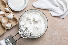 Beaten Egg Whites With Sugar  For Meringue In A Mixing Bowl With An Electric Hand Whisk. Cooking Process With Kitchen Utensils.