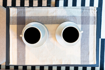 2 cups of hot coffee  on a rustic table background wrapped in cloth. view from the top. space for text. the concept of heat. holidays and events.