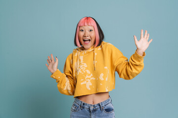 Wall Mural - Asian girl with pink hair and piercing expressing surprise at camera