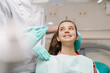 © Drobot Dean - White girl sitting in medical chair while dentists fixing her teeth