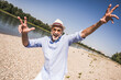 © Westend61 - Playful senior man at riverbank on sunny day