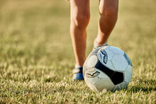 Legs Of Boy In Front Of Soccer Ball At Sports Field