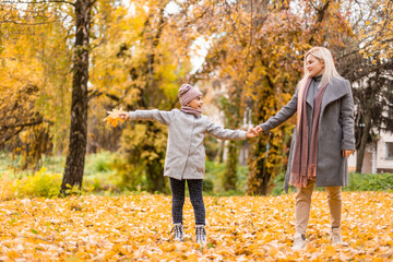 Wall Mural - Mother and daughter in autumn yellow park.