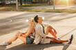 © Syda Productions - summer holidays and people concept - happy young couple sitting back to back and blowing bubble gums on basketball playground