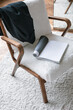 Trendy chair, magazine with open blank page, stylish jacket, soft carpet. Modern Nordic Scandinavian interior design concept. 