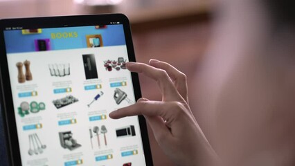 Closeup hand holding tablet browsing online shopping. Person looking for household product on website store selecting item