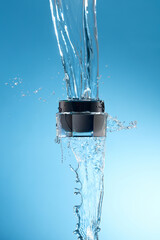 Front view of flying cosmetic jar with water splash in surface with blue background 