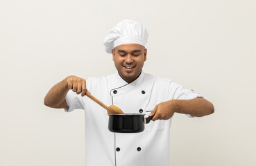 Young asian man chef in uniform holding soup pot utensils cooking in the kitchen various gesture action on isolated background. Indian man Occupation chef restaurant and hotel.