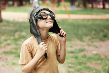 Wall Mural - Young ginger boy with goggles and pilot's hat standing outdoors