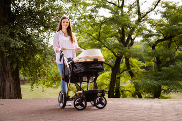 Wall Mural - Photo of charming cute mother dressed casual clothes smiling enjoying summer walk little son outdoors backyard