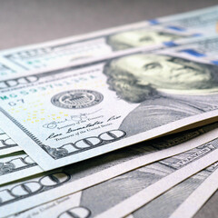 Wall Mural - american paper money. several one hundred dollar bills lie on a gray textured surface. focus on the 