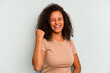 © Asier - Young Brazilian woman isolated on blue background cheering carefree and excited. Victory concept.