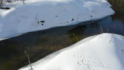 Wall Mural - Drone shot flying on winter river. Frozen river at sunny winter day.
