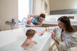 © zinkevych - Woman and man looking at baby in bathtub