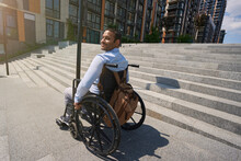 Pleased Disabled Person Seated In Manual Wheel Chair Outdoors