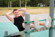 © Евгений Шемякин - Happy fit fitness handsome athletic guy,  young man training abs on bench, doing abdominal exercise on a public equipment in outdoor fitness park. Workout and bodybuilding concept, healthy lifestyle.