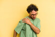© Asier - Young caucasian man isolated on yellow background having a shoulder pain.