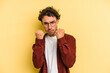 © Asier - Young caucasian man isolated on yellow background upset screaming with tense hands.