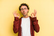 © Asier - Young caucasian man isolated on yellow background relaxes after hard working day, she is performing yoga.