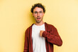 © Asier - Young caucasian man isolated on yellow background surprised pointing with finger, smiling broadly.