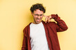 © Asier - Young caucasian man isolated on yellow background covering ears with hands.