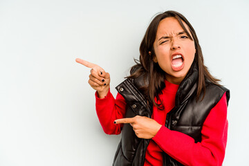 Wall Mural - Young hispanic woman isolated on blue background showing fist to camera, aggressive facial expression.