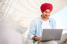 Indian Freelancer Man In Traditional Turban Pagg Sitting Outdoors With Laptop, Developer Working On The Distance, Hindu Guy Enjoys Remote Work, Male Student Studying Online, E-learning Concept