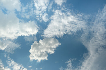 Wall Mural - the white clouds have a quaint and rural shape. the sky is cloudy and blue