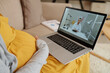 © DragonImages - Close-up of pregnant girl sitting on sofa with laptop and talking to doctor during online consultation
