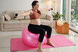 © DragonImages - Young pregnant girl sitting on fitness ball and doing breathing exercises with dumbbells, she training at home