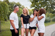 © Andrii - Confident man flirting with three young sporty women in public park, asian and black ladies discussing him and laughing