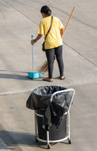 A Young Woman Sweeps The Street