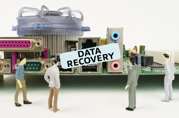 Poster - Figures of people are standing near the motherboard and looking at the sticker with the inscription - Data Recovery