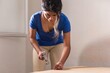 © Sangiao_Photography - Latin Bolivian strong and independent success woman assembly and repair furniture with hammer.