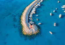 Aerial View Of Boats And Yachts In Dock, Breakwater And Blue Sea