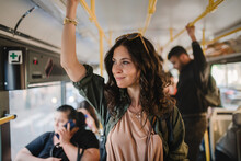Mid Adult Woman Commuter Is Standing In Bus And Travelling In Public Transport.