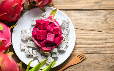 Wall Mural - dragon fruit slice on white plate with pitahaya background , fresh white and red purple dragon fruit tropical in the asian thailand healthy fruit concept - top view