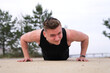 © Евгений Шемякин - Portrait of handsome sportive fit fitness man, athlete, athletic guy doing push ups workout exercise on ground, training outdoors at summer sunny  day in park. Healthy lifestyle. Open air gym