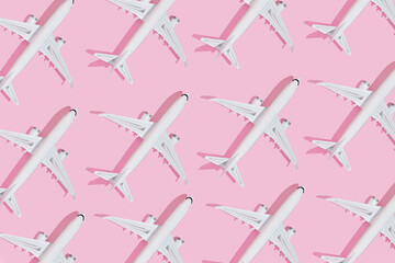 Wall Mural - Airplanes on pink pastel color background .Flat lay design.Summer travel or vacation concept. Top view on Creative composition made with passenger planes on pastel pink background.