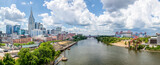 Fototapeta  - The Cumberland River flows through the city of Nashville, Tennessee, with downtown skyscrapers rising on one bank and a professional football stadium on the other.