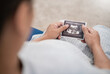 © paulaphoto - Asian or caucasian pregnant woman holding ultrasound 4d scan image, Expectation of a child and Maternity prenatal care.Parenthood, bonding together, woman pregnancy concept banner