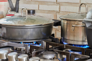 Canvas Print - Preparing food in frying pan and casseroles on the gas stove in the kitchen. Home cooking concept