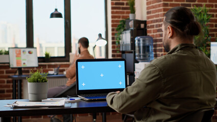 Poster - company employee working on laptop with greenscreen, using isolated chroma key template on computer.