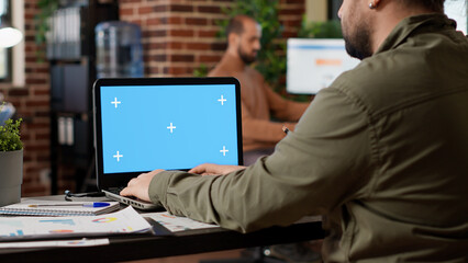 Poster - businessman working on freelance with greenscreen on laptop in company office. looking at pc display