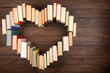 Love of reading concept. Book heart on the wooden background. Copy space for text