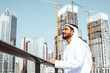 © oneinchpunch - Arabic businessman looking at the skyline in Dubai