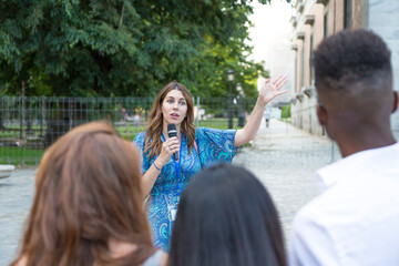 focus on a tour guide talking to a group of tourists