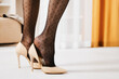 Closeup view in profile at female legs in polka dot pattern and stilettos